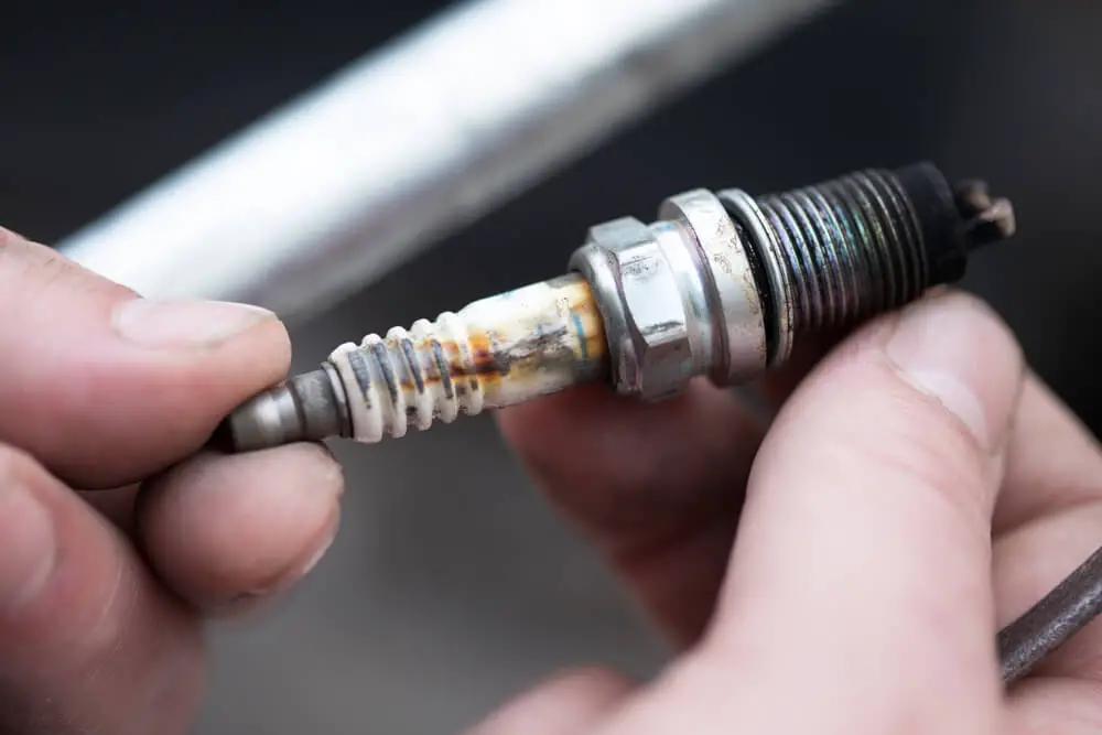 what causes wet black spark plugs